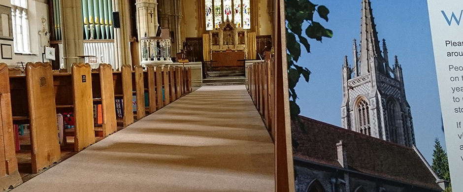 Rows of pews within a church with a sign in the foreground saying welcome